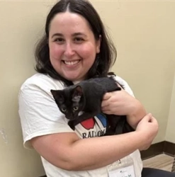 Lindsay Mann, seated while holding a black cat.