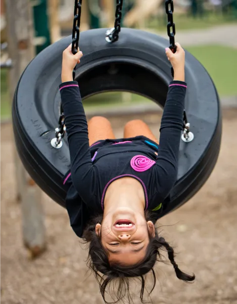 Child playing on a tire swing