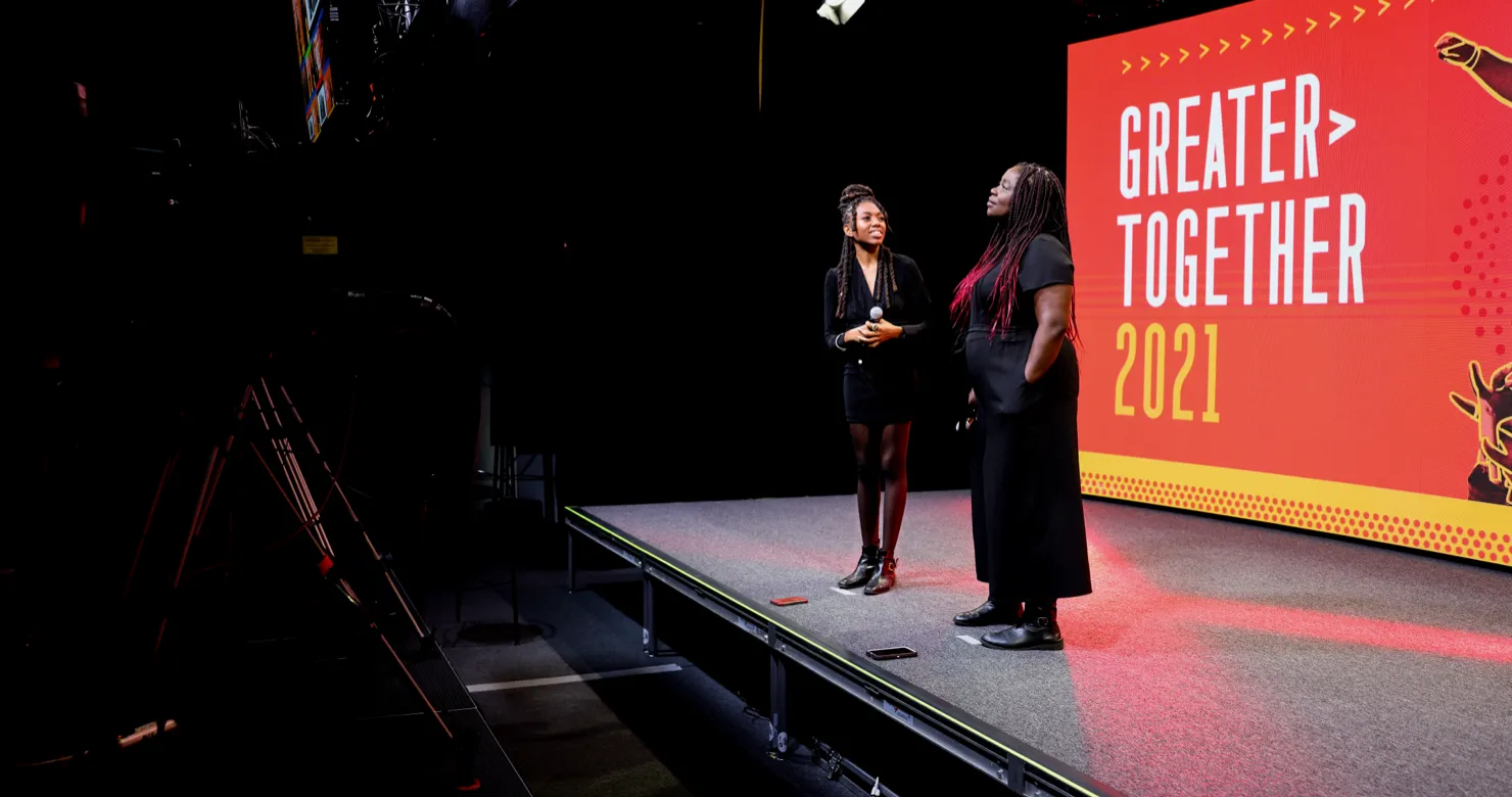 Two women speaking on a stage
